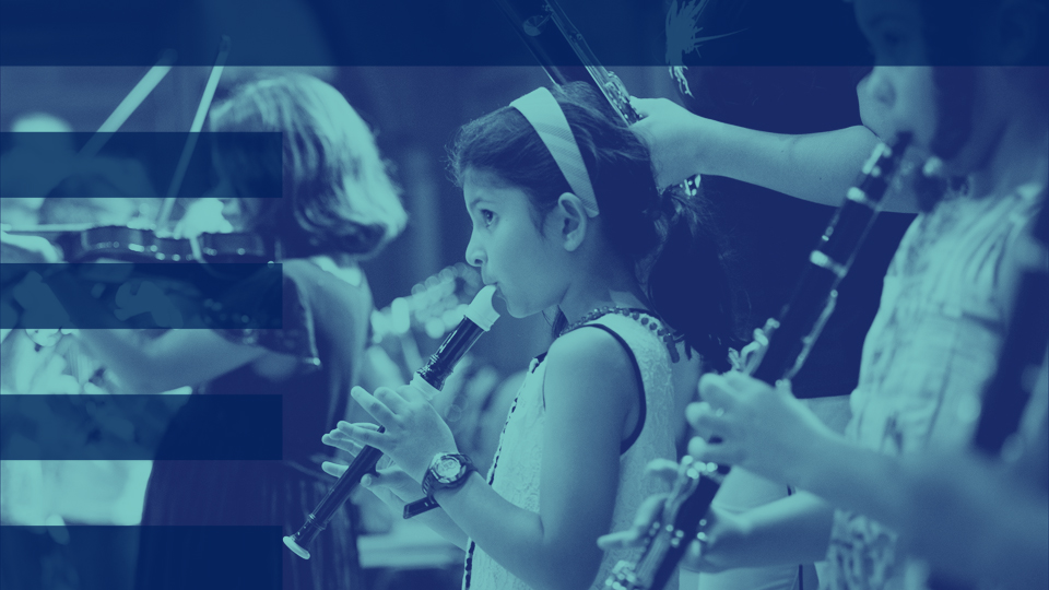 A blue filter photo of a young girl, playing the recorder, with other younger students performing other instruments in the background.